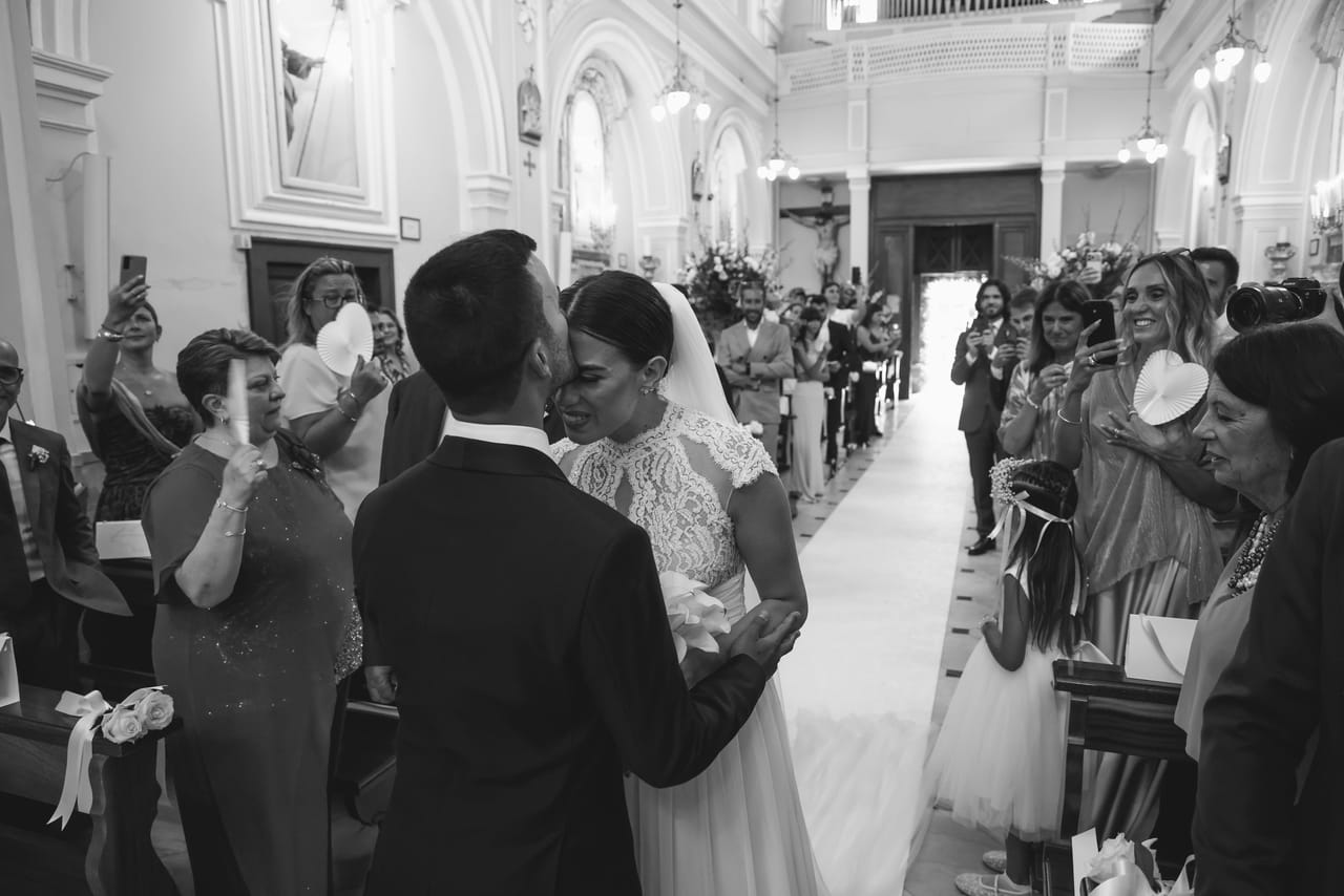 In bianco e nero, gli sposi si incontrano all'altare in una chiesa gremita di invitati